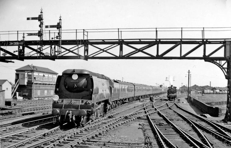 Up 'Man of Kent' entering Ashford station
20th April 1957
The 'Man of Kent' was 12.40pm from Margate via Ramsgate and Dover to Charing Cross (arr. 3.48pm), here headed by Bulleid 'Battle of Britain' Light Pacific no.34083 '605 Squadron' (built October 1948, withdrawn June 1964). On the right in a siding is an H Class tank with Ashford Locomotive Works beyond.
 Ben Brooksbank (CC-by-SA/2.0)
