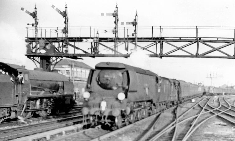 Up Continental Express entering Ashford
23rd August 1958
Passing on the Up Through line, the Boat Express is headed by one of the several Bulleid Light Pacific's, no.34092 'City of Wells', built September 1949, not rebuilt and withdrawn November 1964: it was preserved.
On the left, at the Down main platform is SR Maunsell class V 'Schools' no.30911 'Dover' (built December 1932, withdrawn December 1962) on a Down express.
© Ben Brooksbank (CC-by-SA/2.0)
