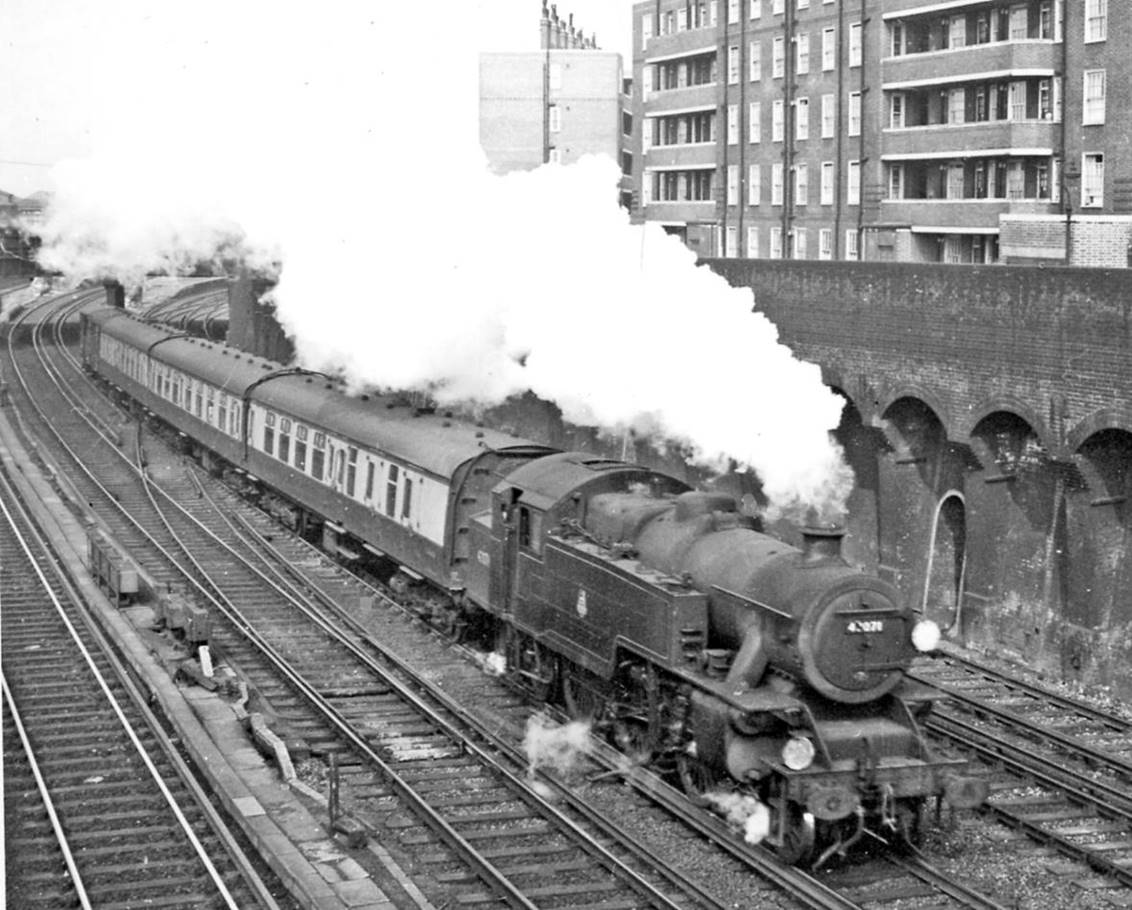Victoria - Tunbridge Wells West train leaving Clapham Junction.
2nd April 1958
North from the Strath Terrace bridge with Clapham Junction Station just visible far left, just passing over Falcon Junction is the 2.08pm from Victoria, headed by LMS Fairburn 4MT no.42071 (built November 1950 at Brighton, withdrawn March 1967 having spent its life on the SR) hauling a Mk1 3-Cor set and van. 
“The flats on the right are the Peabody Estate”.
© Ben Brooksbank (CC-by-SA/2.0)
