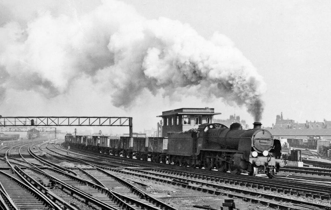 Down Central Section freight at Clapham Junction
2nd April 1958
From the London-end of the Central Section (ex-LBSCR) platforms towards. The train is just passing Clapham Junction 'B' Box, which controlled the Central Section lines; on the right is Falcon Road ex-LMS Goods Yard and in the left distance can be seen the Western Section carriage-washing plant.
© Ben Brooksbank (CC-by-SA/2.0)
