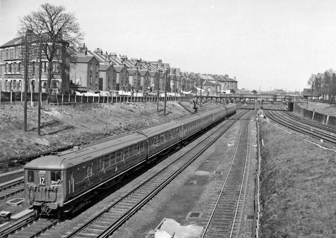 Waterloo – Alton /Portsmouth train west of Clapham Junction
2nd April 1958
The train is the 12.27pm service from Waterloo made up of 8 no. 2 BIL EMU's, which will divide at Woking. On the right is the Brighton main line.
© Ben Brooksbank (CC-by-SA/2.0)
