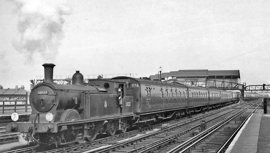 Empty stock from Waterloo arriving at Clapham Junction
2nd April 1958
Seen from the London end of Platforms 7/8, the train is running under the great 'A' Box into the Carriage Sidings, headed by ex-LSW Drummond M7 class no.30123 (built February 1903, withdrawn July 1959). The first three coaches are Bulleid Multidoor set no.976 formed (nearest) BSK 2868, CK 5722 & BSK 2867.
I recorded this particular engine on 107 occasions - more than any other number on any railway .
Ben Brooksbank (CC-by-SA/2.0)