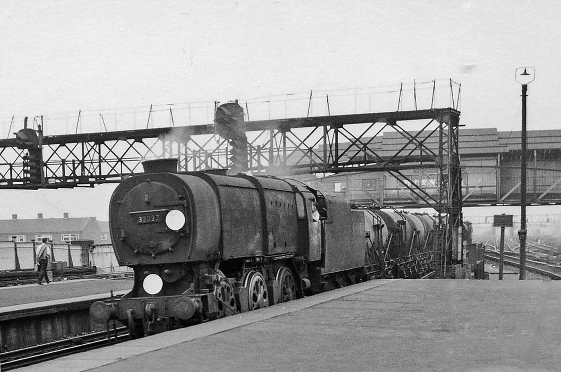 Down milk empties at Clapham Junction (Windsor Lines)
18th July 1964
The train (probably from the Milk Depot at Vauxhall) is passing under the great 'A' signalbox (with its wartime steel canopy) and along the platform 4 line towards Putney, Richmond etc., headed by Bulleid wartime Q1 class no.33027 (built July 1942 as C27, withdrawn January 1966).
© Ben Brooksbank (CC-by-SA/2.0)
