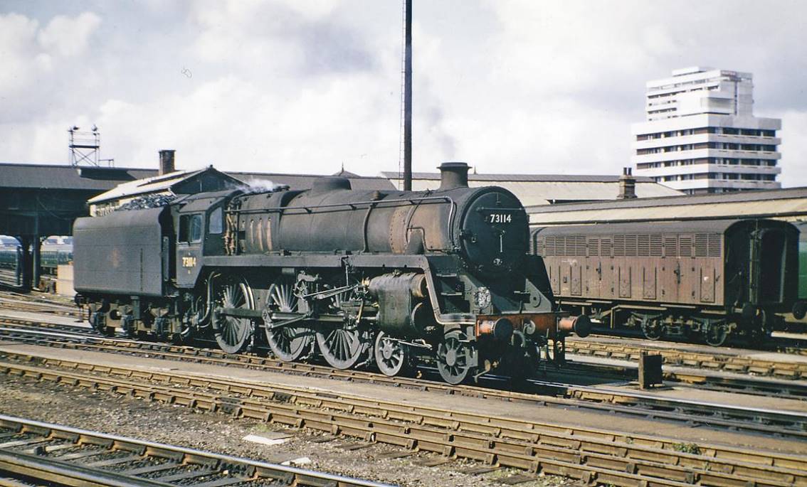 Clapham Junction (Windsor Lines), with BR Standard 4-6-0
9th September 1965
From Up Main platforms 7/8 across the lines into the Carriage Yard to the Windsor Line platforms 1-6. The filthy BR Standard 5MT is no.73114 'Etarre' (built November 1955, withdrawn June 1966), latterly carrying the name previously borne by 'King Arthur' class no.30751 which was withdrawn in June 1957.
In Alfred Tennyson's Idylls of the King, Sir Pelleas (knighted by King Arthur) deeply loves the maiden named Etarre (who does not return his affection).
© Ben Brooksbank (CC-by-SA/2.0)
