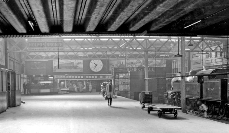 BloodandCustard Euston Station 1962
Platform 12/13
To the barriers on Platform 12/13. On the right is Fowler no. 42367 at Platform 14 on empty stock it has brought in from Willesden.
Immediately above is a bridge for vans leading from Cardington Street to Platforms 11 and 10 where parcels etc. were loaded.
Ben Brooksbank (CC-by-SA/2.0)