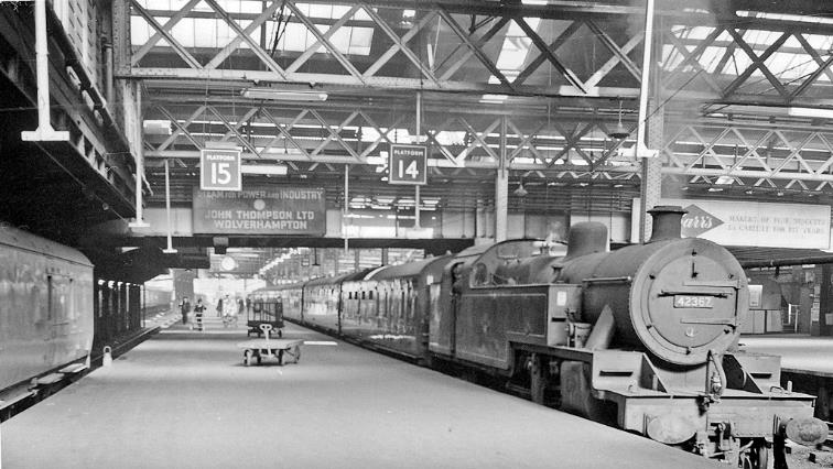 BloodandCustard Euston Station 1962
Platform 14/15
Departure side: outward view with the empty stock of a Down express near the buffer-stops of platform 14 brought in from Willesden by LMS Fowler 4P no. 42367.
This was the great old, rambling station not long before it was rebuilt in 1966. The main Departure side (Platforms 12-15) were separated by various structures (including the Great Hall) and local platforms from the Arrival side well away on the east side.
© Ben Brooksbank (CC-by-SA/2.0)
