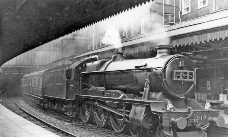 BloodandCustard
Paddington Station
'County' 4-6-0 about to leave Paddington with a Worcester line express
24th April 1948
This is the 1.45pm departure, calling at Reading, Didcot, Oxford and principal stations via Worcester to Hereford (due 6.25pm - rather a slow journey). Hawksworth 'County' no.1017 'County of Hereford' was built March 1946, has yet to receive its smokebox number-plate and later a double-chimney; it was withdrawn December 1962. The train is at Platform 1 with the locomotive out beside the extension leading to the parcels station.
 Ben Brooksbank (CC-by-SA/2.0)
