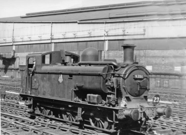 BloodandCustard
Paddington Station
Condenser-fitted Pannier tank
25th August 1956
Ex-GWR condenser-fitted Pannier tank at Paddington. Supplementing the converted no.8700 (renumbered no. 9700), ten of the Collett '8750' class Pannier tanks were built new in 1933 for the traffic on the Metropolitan Underground route from Paddington to Smithfield. 
With condensing apparatus and other modifications. No. 9701 (built September 1933, withdrawn June 1961) is seen here off the end the Arrival platforms at Paddington, with the great Goods Station behind, beyond the electrified Hammersmith & City lines.
© Ben Brooksbank (CC-by-SA/2.0)
