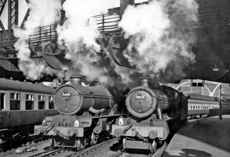 BloodandCustard
Paddington Station
Weymouth departure
23rd May 1958
Seen from Platform 2/3, 'Castle' no.5001 'Llandovery Castle' leaving from Platform 4 on the 6pm express to Weymouth, while 'Modified Hall' no.7927 'Willington Hall' backs down onto a train at Platform 3. On the left empty stock is running into Platform 5. 
The 'Castle' was already 32 years old and lasted another five years, but the Modified 'Hall' was a 'youngster' built in October 1950 and withdrawn in December 1965.
 Ben Brooksbank (CC-by-SA/2.0)
