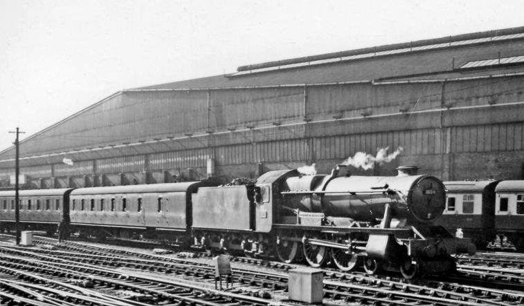 BloodandCustard
Paddington Station
'County' propels empty stock from Paddington
23rd May 1958
Propelling stock from a local train out of Platform 9 or 10 is Hawksworth' County' no.1004 'County of Somerset' (built October 1945, withdrawn September 1962 - the first to go). Behind is the massive Paddington Goods station.
 Ben Brooksbank (CC-by-SA/2.0)
