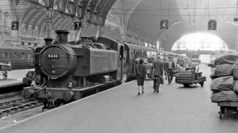 BloodandCustard
Paddington Station
Large Pannier Tank on empty stock work at Paddington
28th June 1962
From near the barriers on Platforms 4/5, Hawksworth '9400' class no.8436 (built May 1953, withdrawn June 1965) has brought in from Old Oak Common the stock for the next express from Platform 4. Note the trolleys piled with bags of Mail.
 Ben Brooksbank (CC-by-SA/2.0)
