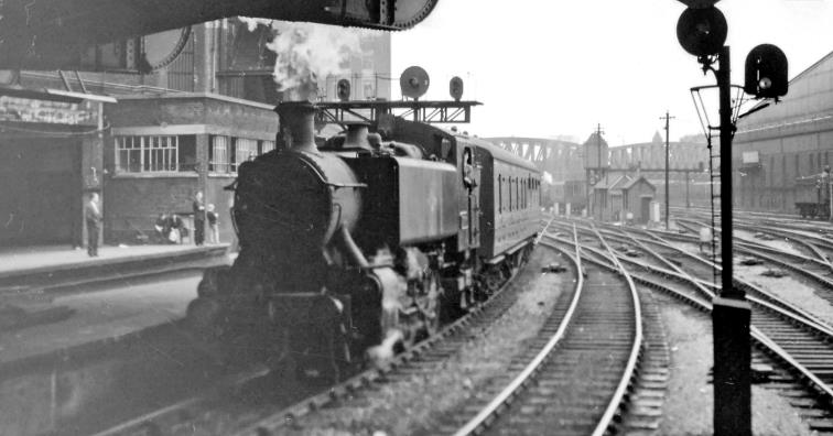 BloodandCustard
Paddington Station
Empty stock coming into Paddington Station
28th July 1962
From Platform 4/5 under Bishop's Road Bridge, Hawksworth '1500' class no.1506 (built September 1949, withdrawn December 1963) is bringing the stock into Platform 3 from Old Oak Common Carriage Depot. Behind is the Departure Signalbox and the Parcels Station: ahead is Westbourne Bridge and to the right Paddington Goods.
 Ben Brooksbank (CC-by-SA/2.0)
