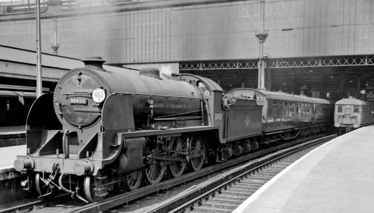 'King Arthur' at Waterloo
11th May 1959
A typical scene at Waterloo Station in the 1950's. At one of the main line platforms (no. 12), N15 Class no.30453 'King Arthur' (after which the Class was known) was not the first of the Class, being a Maunsell-modified Urie variant built post-Grouping in February 1925 (withdrawn in July 1961). Here in its latter days it is on the 2.54pm stopping train to Basingstoke – the first coach being of Bulleid 3-Set set 771 (new 5th December 1946); at Platform 11 is an 2 BIL leading a service to Alton.
© Ben Brooksbank (CC-by-SA/2.0)
