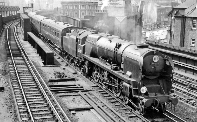 Down express from Charing Cross entering Waterloo (East 
11th May 1959
From the footbridge linking Waterloo Main Station, towards Charing Cross River Bridge, the 3.08pm Charing Cross - Deal (via Tonbridge, Ashford, Folkestone and Dover) is headed by SR rebuilt Bulleid Light Pacific no.34027 'Taw Valley' (built April 1946 as no.21C127, rebuilt September 1957, withdrawn August 1964 and now preserved).
The leading coaches are Bulleid 4-Set (new 24th March 1949, withdrawn 16th May 1964). 
  Ben Brooksbank (CC-by-SA/2.0)