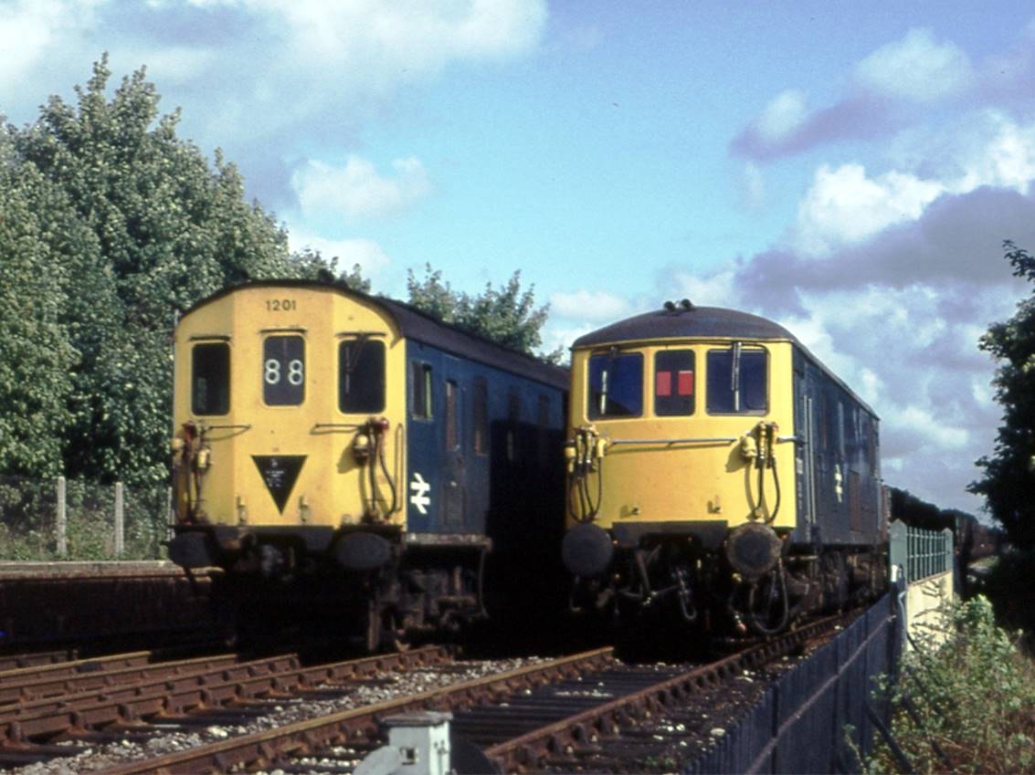 Unit no.1201 passes an engineer's train stabled in Edenbridges Up siding ready for engineering work. In September 1975 there were enough available locomotives and sidings enabling the operating authority to send out engineer's trains in advance and just leave them parked in readiness for the weekend work.
 Tony Watson

