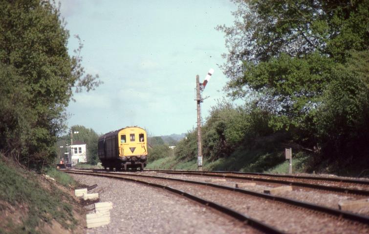 I wandered lonely as a Cloud
Following its stop at Edenbridge, unit no.1203 near Hilders Farm on Thursday, 24th May 1979. No-doubt the driver will be grateful for the sun visor for he is driving directly into evening sun on the straight East - West railway line across to Redhill.
The inverted black triangle provided an early indication to station 
staff that there was No brake van at the other end of the unit.
 John Atkinson
