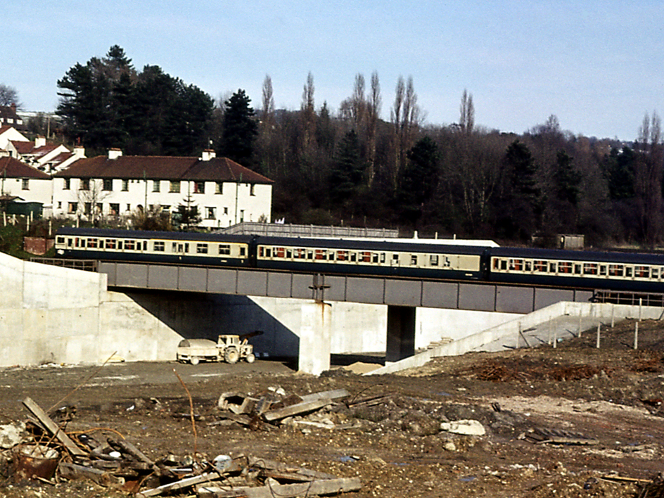 https://www.bloodandcustard.com/BR-4VEP.html
Against the backdrop of Ashcombe Road, on Good Friday, 28th March 1975 a 4 VEP unit heads north from Merstham station over the M25 construction works below.
While the train is about to pass under the M23 motorway (opened on 19th December 1974); this section of the M25 motorway didn’t open until 10th February 1976.
© Tony Watson