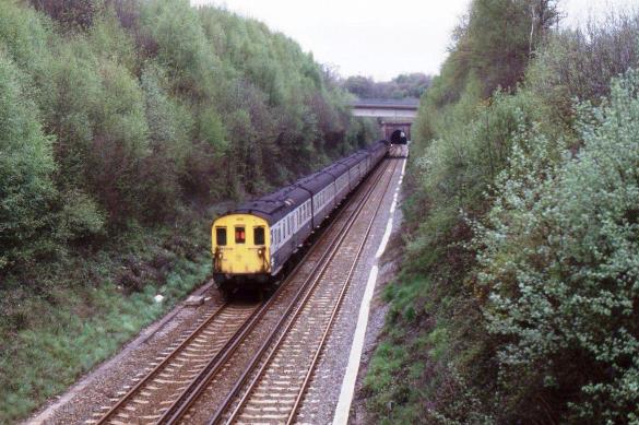 https://www.bloodandcustard.com/BR-6S-6L-6B-Hastings.html
Just beyond Vauxhall Lane overbridge is the ‘new’ A21 Tonbridge by-pass and unit no.1001 (behind no.1012) is about to enter Somerhill Tunnel with the 12.43 from Hastings.
“Note the conductor rail is located in the sixfoot throughout; one feature of the Hastings line electrification scheme”.
John Atkinson ©