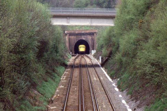 https://www.bloodandcustard.com/BR-6S-6L-6B-Hastings.html
Now full of exhaust resulting in absolutely no visibility through its length, unit no.1017 slowly emerges from the tunnel.
© John Atkinson
