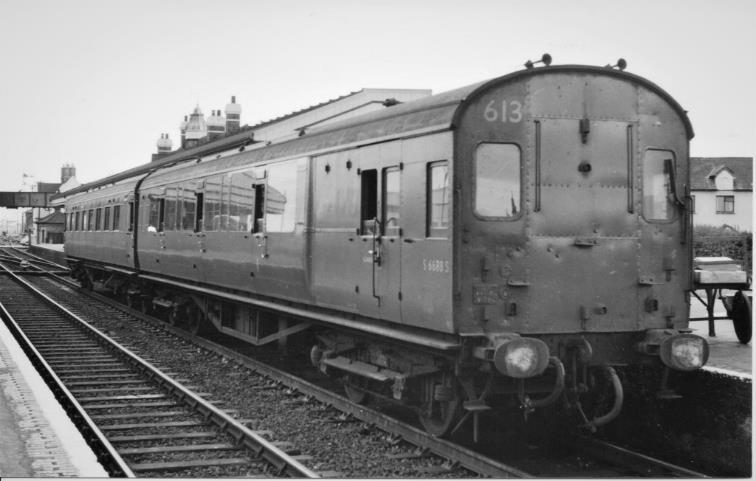 Southern Region
Pull-Push Sets
(Maunsell rebuilds 600-619)
Following the cessation of pull-push workings on Saturday, 16th May 1964, and with its locomotive running-round, pull-push set 613 awaits its next hauled turn to Swanage at Wareham on Saturday, 18th September 1964.
The UIC yellow First-class band on the BCK is just visible below the cant-rail and its air-horns clearly apparent on the driving end. Only the driver’s forward observation light was ever equipped with a wiper.
© A.E. West (Mike King collection)
