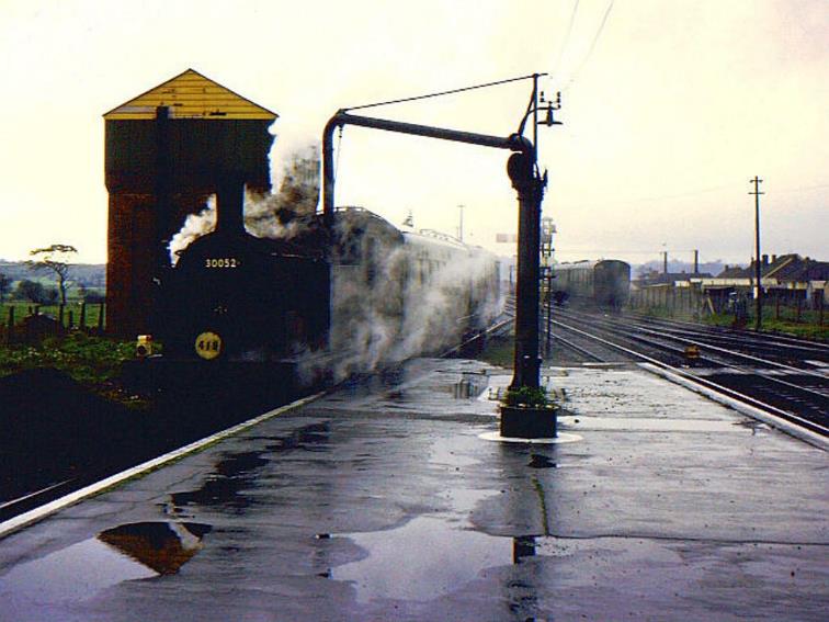 Southern Region
Pull-Push Sets
(Maunsell rebuilds 600-619)
On 9th November 1963, M7 no.30052 (with one of the two unidentified Maunsell pull-push sets in use on the day) takes on water from the tower at Wareham station.
When its tanks are full, the train will continue its shunting move further into the Down bay platform to form the next service to Swanage. 
Note both tail lamp & headcode disc; the latter sporting the driver’s duty number.
In the background, a third ‘spare’ pull-push set sits against the Up siding’s ‘stops’.
© Richard Green (CC-by-SA/2.0)
