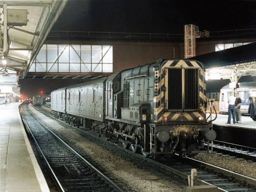 Class 08850 is coupled to two General Utility Vans (GUVs) at Reading Station (Geograph)
