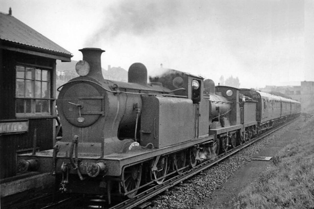 St. Helier 
RCTS South London Rail Tour
Looking towards Wimbledon on 30th September 1950 and the Railway Correspondence & Travel Society South London Rail Tour. Steam locomotives normally only worked on freight (including milk to Morden) from Wimbledon to St Helier, so beyond here ex-SECR C-class no.31722 (built January 1901, withdrawn May 1962) had to take on the assistance of ex-LB&SCR R. Billinton E6 class no.2418 for the 1-in-40 climb on the final stretch up and around the wall of death into Sutton. 
 Ben Brooksbank (CC-by-SA/2.0)
