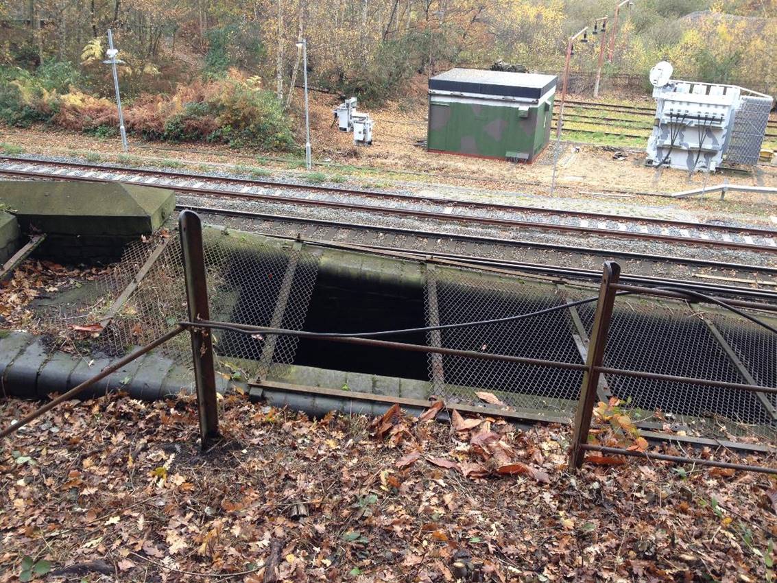 www.BloodandCustard.com

Metal railing and grills protect the tunnels slit-vent.
Beyond is the line from Redhill to Tonbridge thence the sidings. 
 Adrian Backshall
