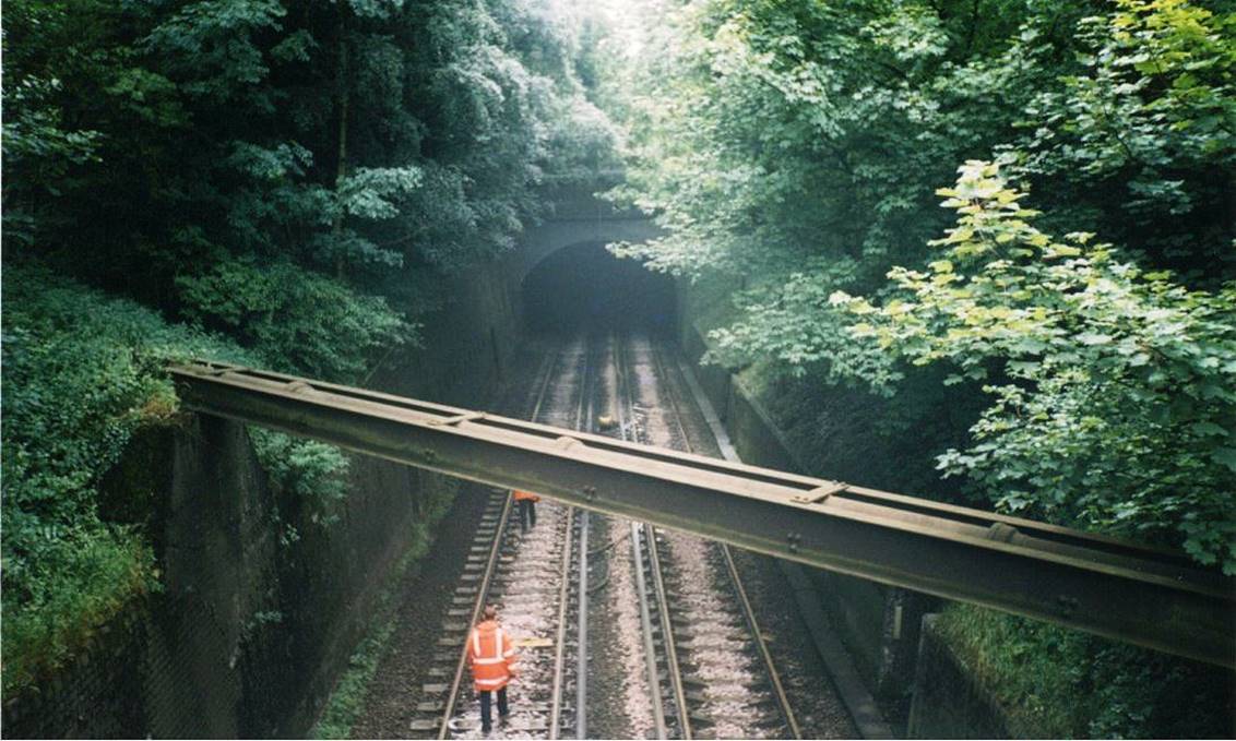 www.BloodandCustard.com

The former covered way and Redhill tunnels north-end portal towards Earlswood from the public footbridge. Note the pipe bridge crossing the railway.
 Colin Watts
