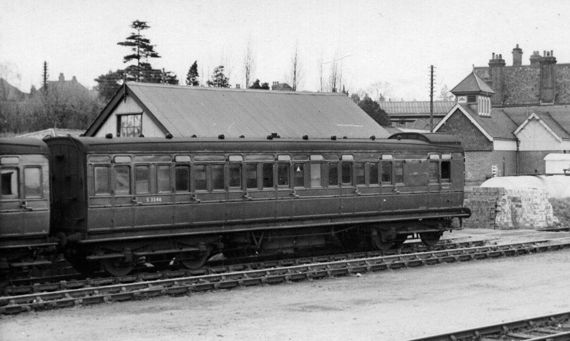 A train on tracks with a building in the background

Description automatically generated