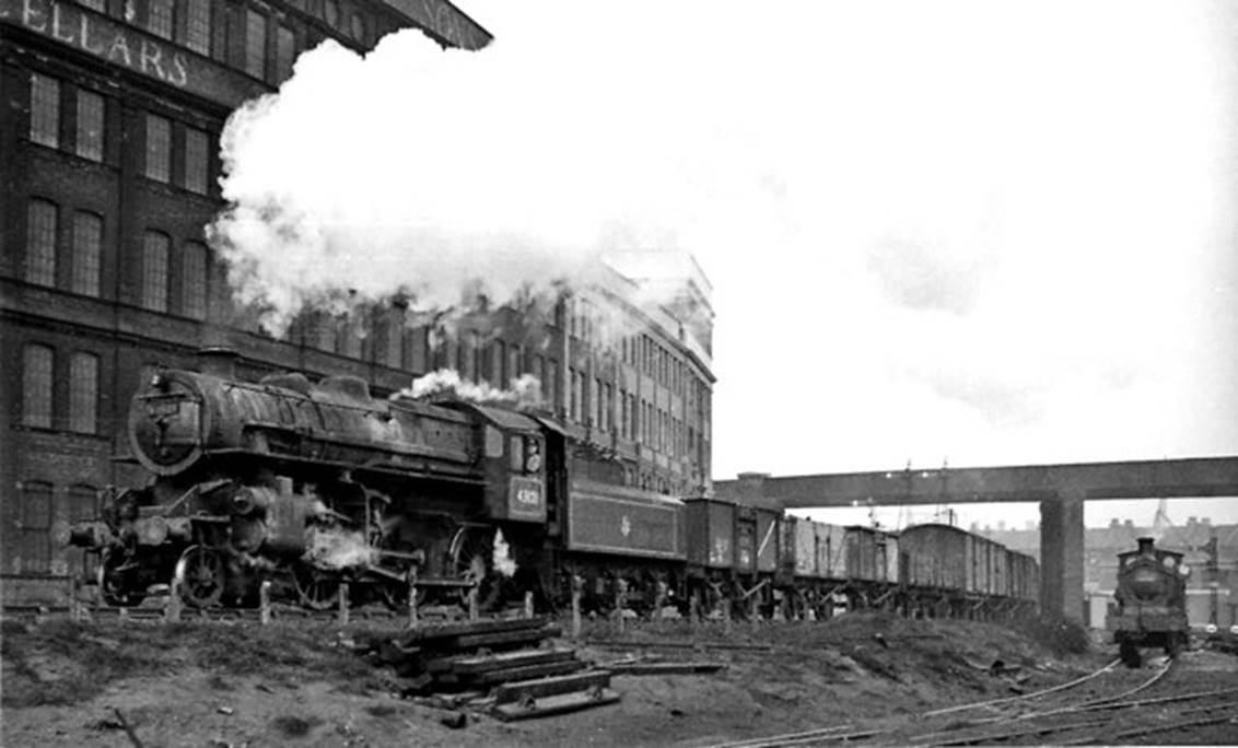 Transfer freight from Battersea Yard to Brent Sidings (Cricklewood) passing Stewarts Lane (alongside the big Harrods furniture repository) on 15th February 1958. The freight is hauled by an LMS-type Ivatt 4MT no.43121 (built August 1951, withdrawn November 1967); on the right is an unidentified ex-SECR C-class locomotive.
View is northward, from Stewarts Lane Locomotive Yard (the Depot is behind photographer) in the complex of SR lines near Queens Road (Battersea) station. The bridge carries the South London line (Victoria - London Bridge), Wandsworth Road being the next station off to the right.
© Ben Brooksbank (Geograph/CC-by-SA)
