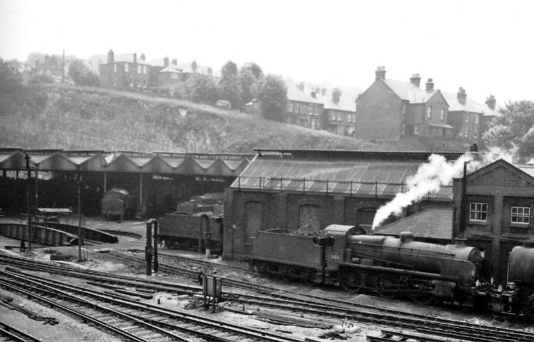 www.BloodandCustard.com
From the Farnham Road bridge (with Chalk Tunnel being off to the left) the cramped, unusual roundhouse has few occupants on Saturday, 5th June 1965. 
The locomotive on the centre right is SR (ex-SECR) Maunsell N class no.31816 (built December 1921, withdrawn January 1966).
© Ben Brooksbank (CC-by-SA/2.0)
