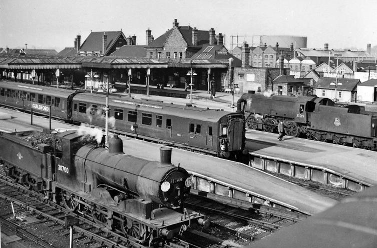 www.BloodandCustard.com
From the Farnham Road bridge of the southern end of Guildford station. In the foreground is ex-LSWR Drummond '700' class no.30700 (built May 1897, withdrawn November 1962); in the centre is a 1938-built 4 COR electric multiple unit at the rear of an Up Portsmouth - Waterloo service; beyond is SR Bulleid wartime Q1 class no.33019 (built May 1942 as no.C19, withdrawn December 1963).
© Ben Brooksbank (CC-by-SA/2.0)
