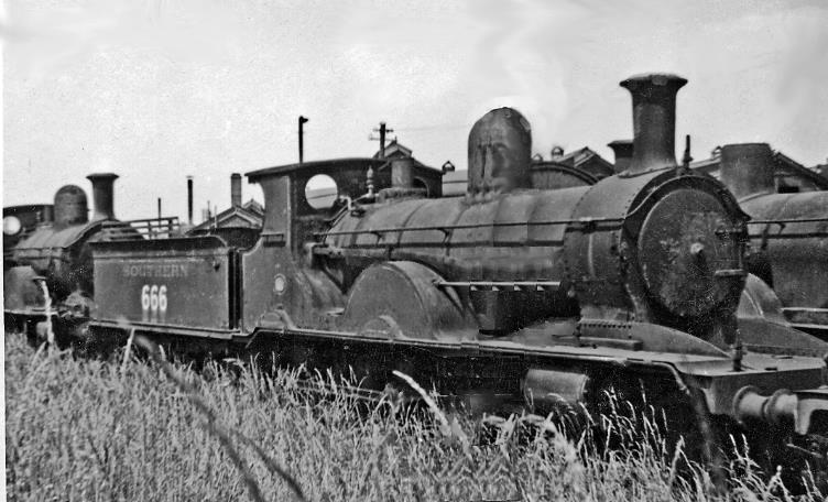 Ancient ex-LSWR dumped at Eastleigh Locomotive Depot. Adams X6 class 4-4-0 no.666 was built in June 1892 and spent its youth on expresses from Waterloo, later on less demanding duties. 
In the end it was so worn out it had to be withdrawn in June 1943 at the height of World War Two when almost any locomotive that could turn a wheel was needed. Along with many other condemned engines, some of which had been there for years, I photographed it in July 1946 rusting away with weeds growing all round. A year or two later, these 'old crocks' were towed away to West Moors and eventually scrapped - at Eastleigh.
 Ben Brooksbank (CC-by-SA/2.0)
