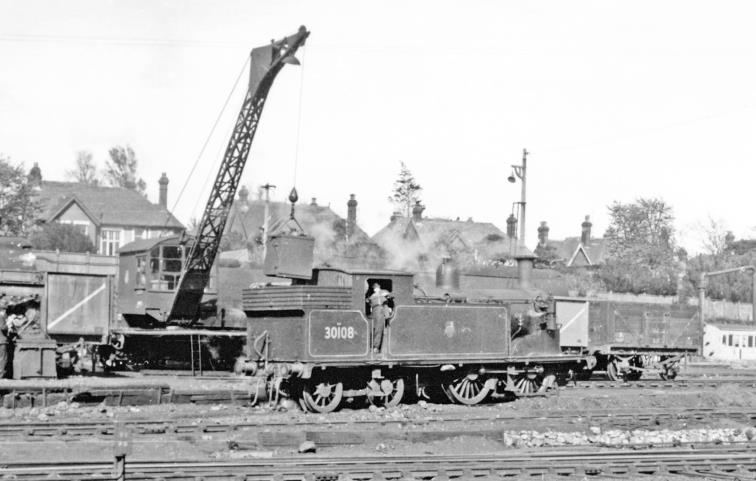 Primitive coaling of a tank engine at Bournemouth on 5th July 1958. The Locomotive Yard was always a sight of interest from the west end of the Down platform at Bournemouth Central. Here ex-LSWR Drummond class M7 no.30108 (built March 1904, withdrawn May 1964) is being coaled by a crane lifting coal from wagon and dropping it - with difficulty? - in then engine's bunker.
© Ben Brooksbank (CC-by-SA/2.0)
